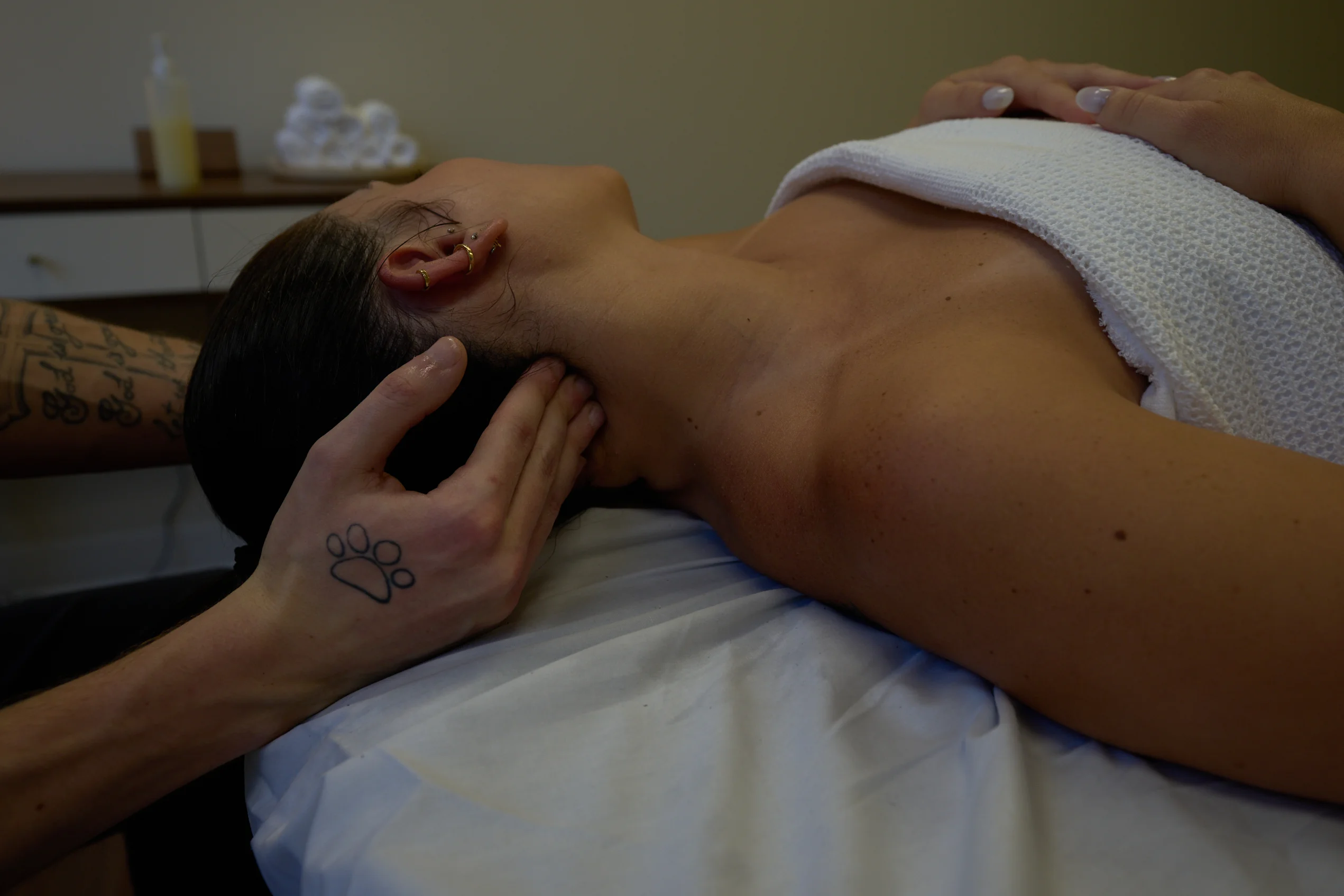 Registered Massage Therapist performing myofascial release on a woman's neck to treat chronic pain and headaches.